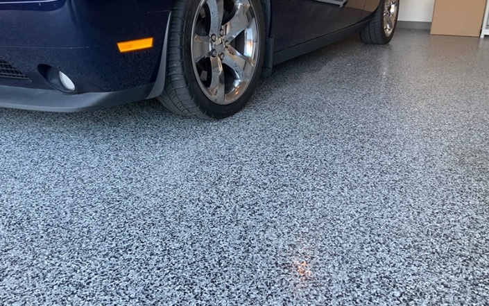 close up of flecked concrete coated garage floor.