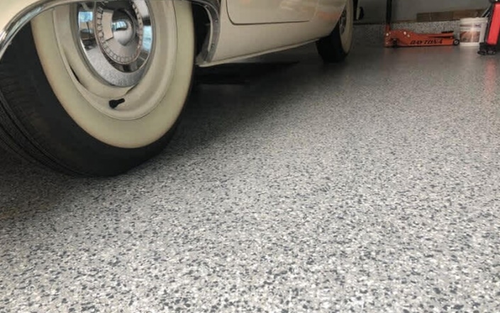 close up of flecked concrete coated garage floor.