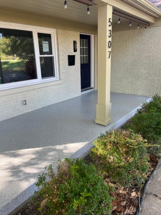 Flecked concrete coated front home patio floor.