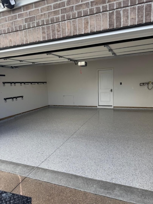 Flecked concrete coated garage floor.