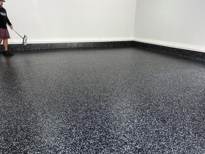 close up of flecked concrete coated garage floor.